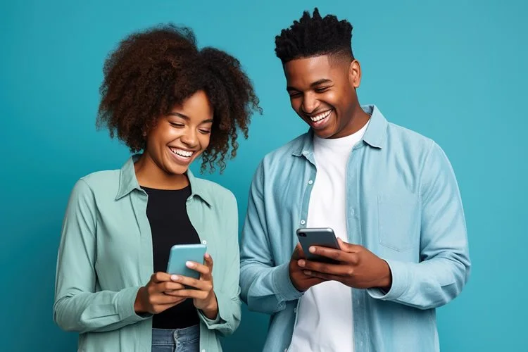 Couple smiling looking at their phones
