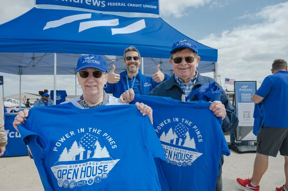 Andrews booth and members holding shirts at the air show