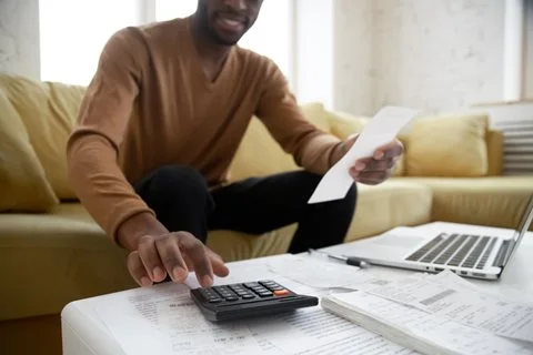 Man with receipts, computer and calculator budgeting