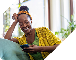 A woman sitting on the couch looking at her mobile phone